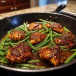 A skillet of 30-Minute Honey Garlic Chicken & Green Beans, glazed and garnished.