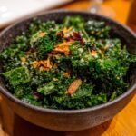 Close-up of a vibrant Kale Crunch Salad in a dark bowl, featuring kale, crunchy toppings, and a light dressing.