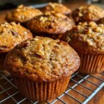 Close-up of several bakery-style MOIST Banana Nut Muffins cooling on a wire rack.