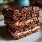 A slice of Ultimate No-Bake Brownie Refrigerator Cake showing layers of brownie and cream filling.