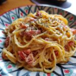 Close-up of 30-Minute One Pot Creamy Tomato Pasta on a colorful plate, garnished with herbs.