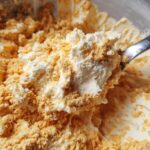 Spoonful of The Pumpkin Fluff dessert, showing the creamy texture and pumpkin spice crumble topping.