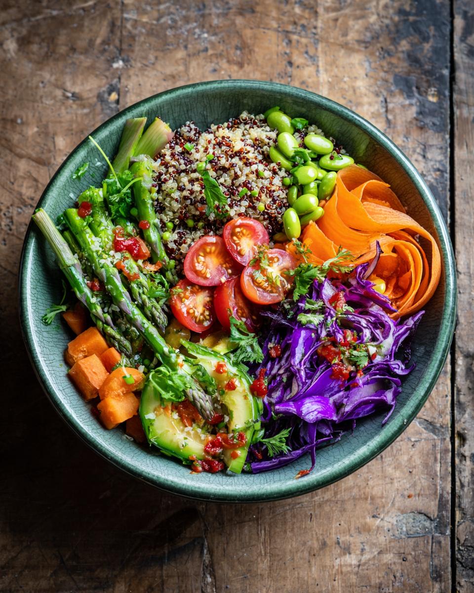 Overhead shot of a vibrant Quinoa Summer Bowl with quinoa, avocado, asparagus, carrots, cabbage, and tomatoes.
