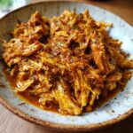Close-up of a bowl filled with flavorful Smoky Chicken Tinga, showcasing its rich sauce and shredded chicken texture.