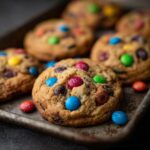 Freshly baked Best Soft & Chewy M&M Cookies on a metal baking sheet, featuring colorful M&Ms.