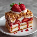 A delicious slice of Strawberry Shortcake Crunch Cake with layers of cream, strawberries, and a crunchy topping.