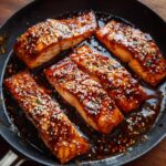 Pan-seared Teriyaki Salmon fillets glazed with teriyaki sauce and sprinkled with sesame seeds.