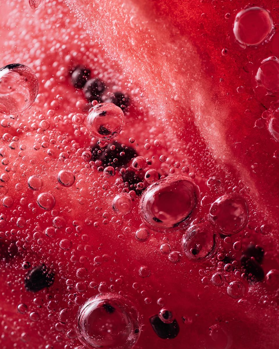 A detailed close-up of watermelon flesh, seeds, and juice bubbles, perfect for illustrating The Watermelon Juice recipe.
