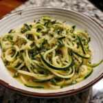 A bowl of vibrant Zucchini Zoodle Pasta, showcasing the spiralized zucchini and light sauce.